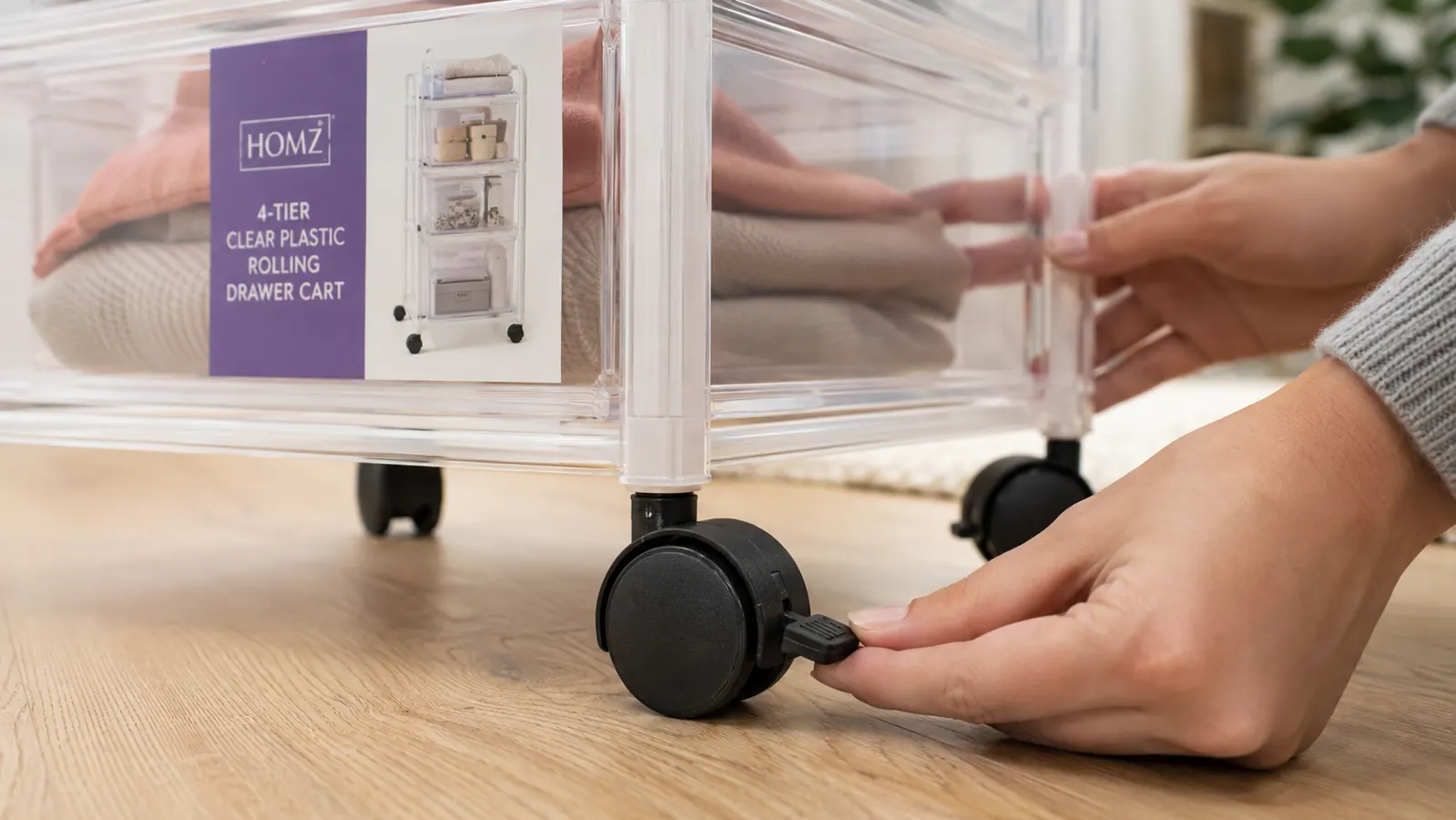 Close-up of the HOMZ cart wheel locks from below, showing two locked and two unlocked casters on a hardwood floor