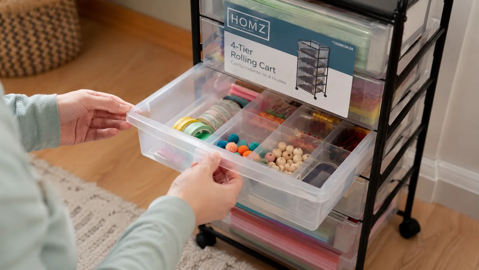 Hand pulling open a HOMZ drawer cart drawer to reveal neatly organized craft supplies inside